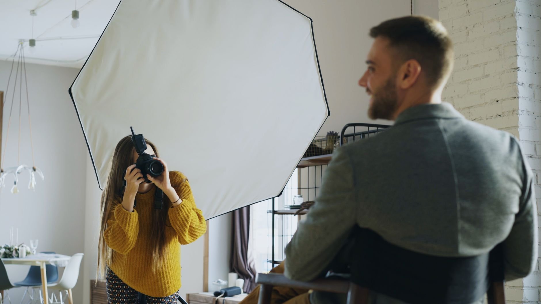A professional photographer captures a portrait using softbox lighting