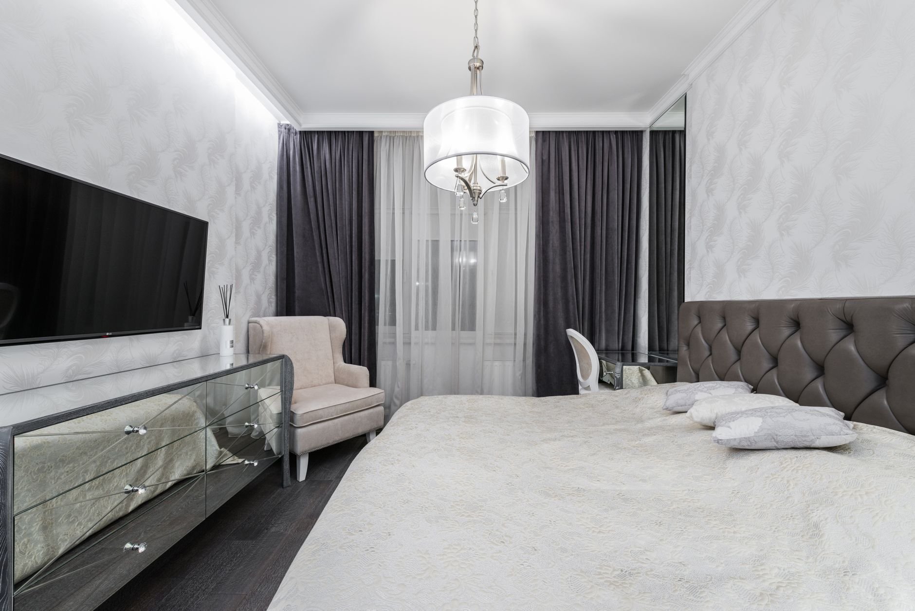 Interior of stylish bedroom with large bed and white linen in a luxury rental apartment